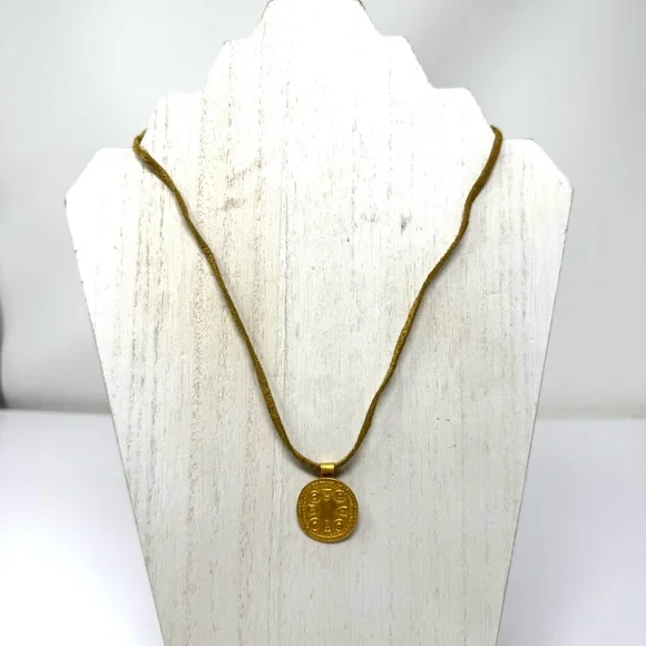 Mayan design gold tone pendant purchased in Costa Rica, on golden suede cord